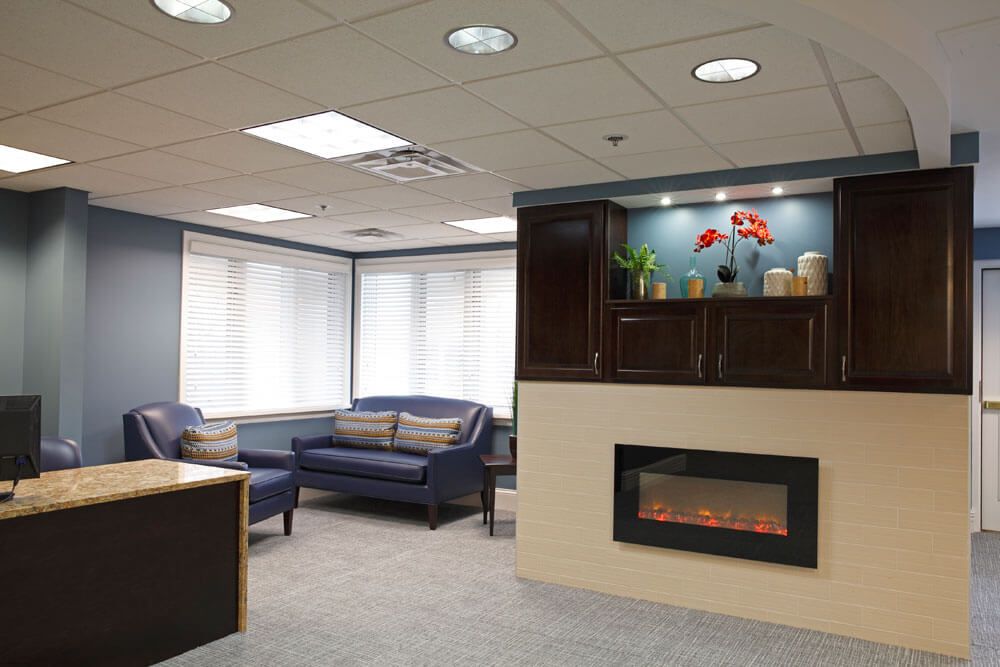 A modern waiting area with a cozy sofa and fireplace.
