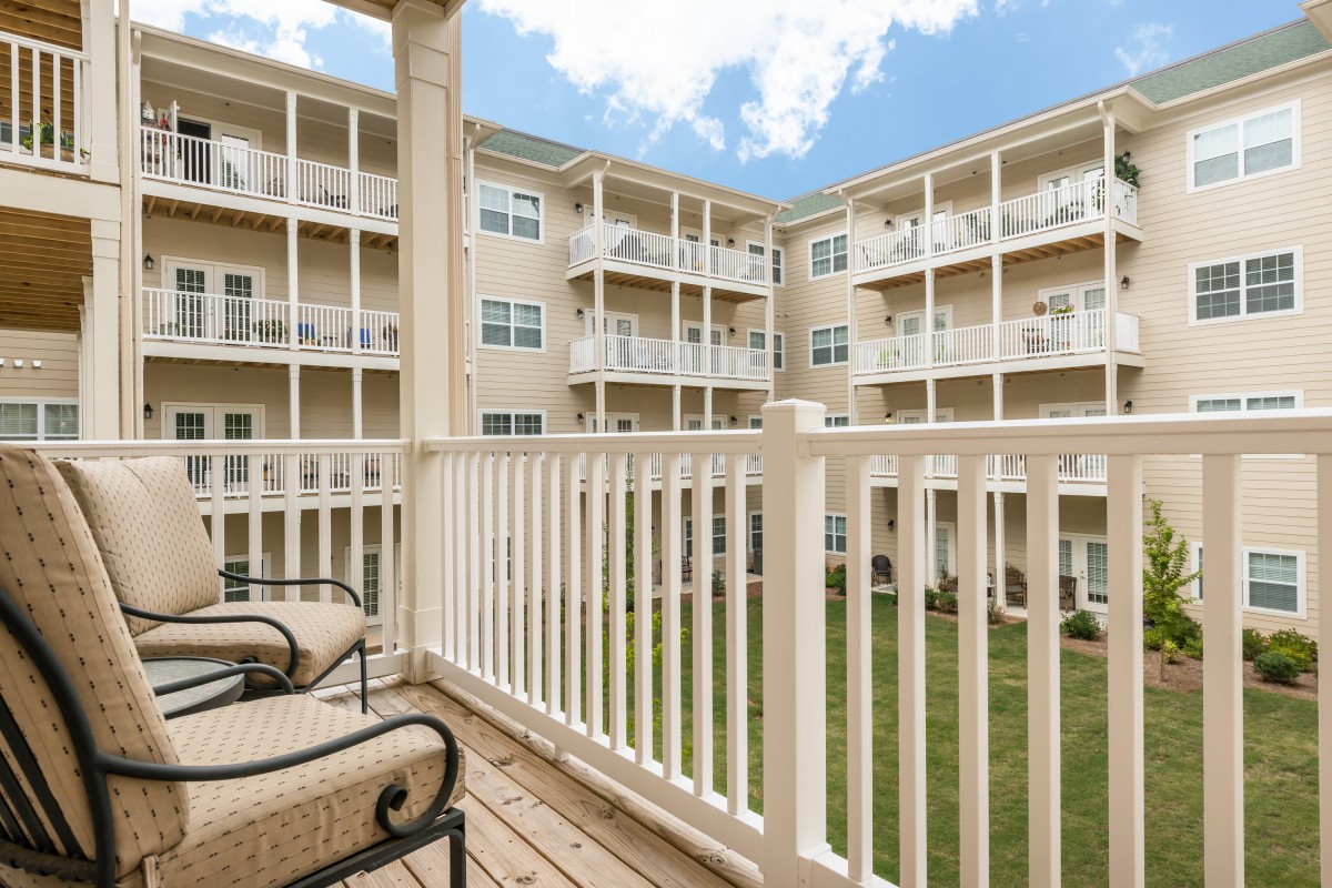 A view from the balcony of an apartment overlooking a courtyard.