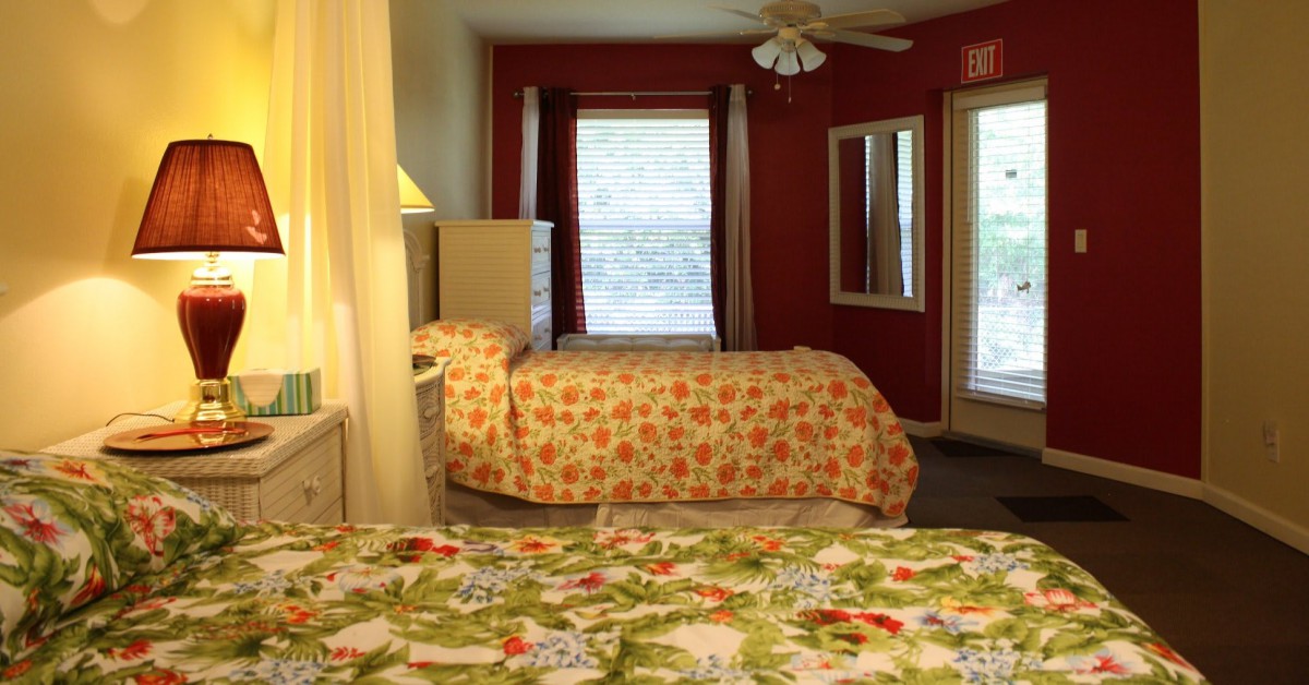 A cozy bedroom interior with two beds and a window in the background.