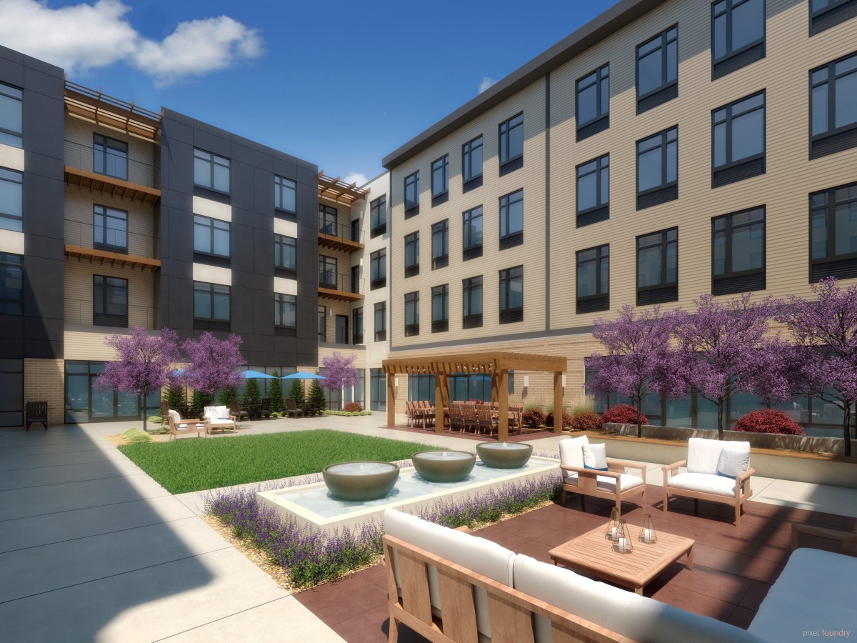 A modern apartment complex with a well-landscaped courtyard featuring outdoor seating and decorative elements.