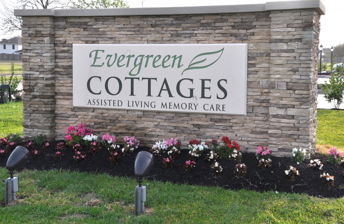Sign for Evergreen Cottages, offering assisted living and memory care services.