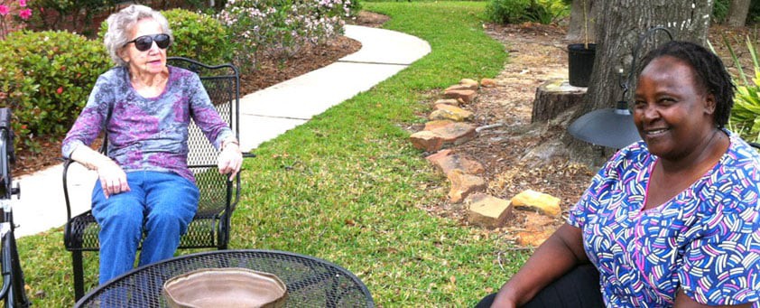 A scenic outdoor patio area with metal chairs overlooking a garden pathway.