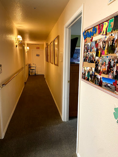 A well-lit hallway adorned with photographs and art, leading to various rooms.