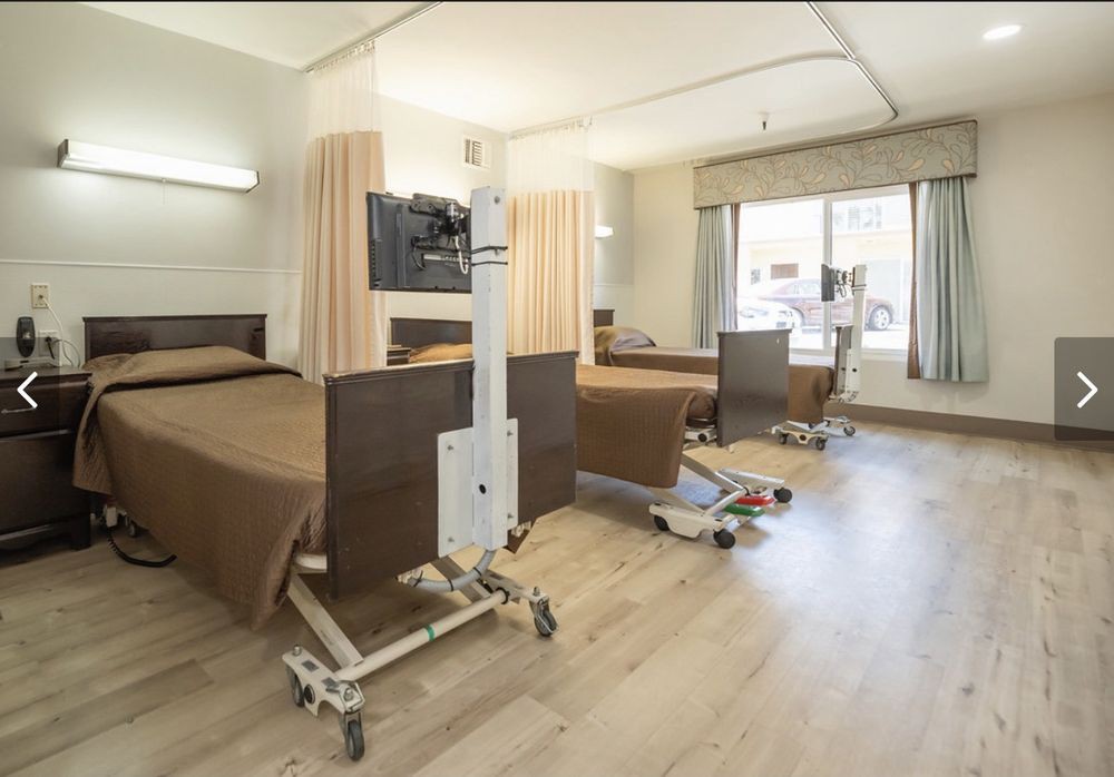 A hospital room featuring two beds and medical equipment.