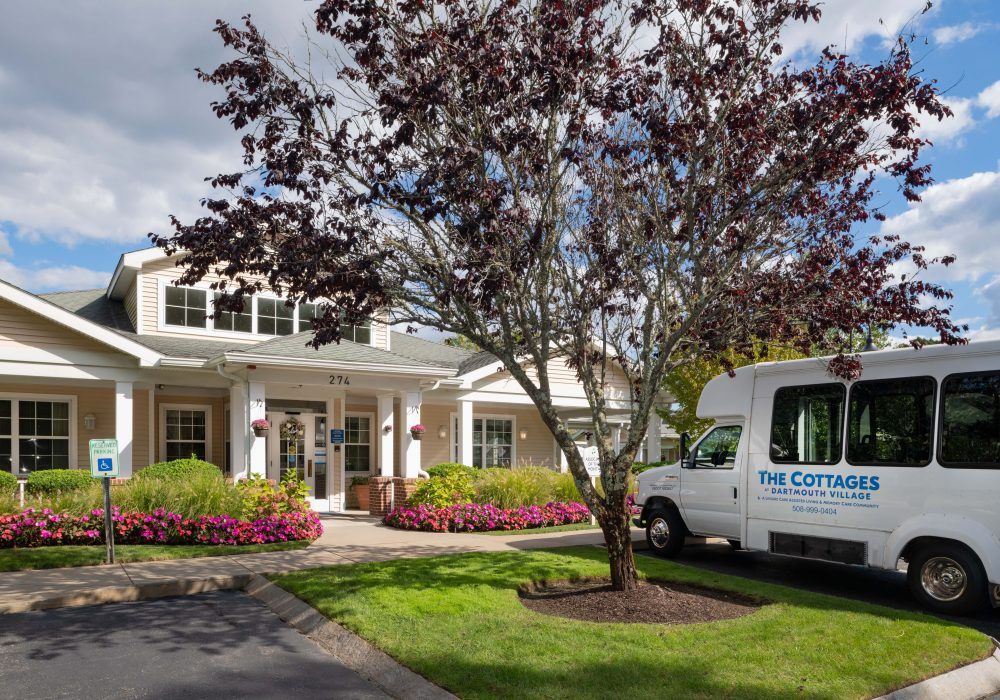A residential house with a van parked in the driveway, surrounded by well-maintained landscaping.