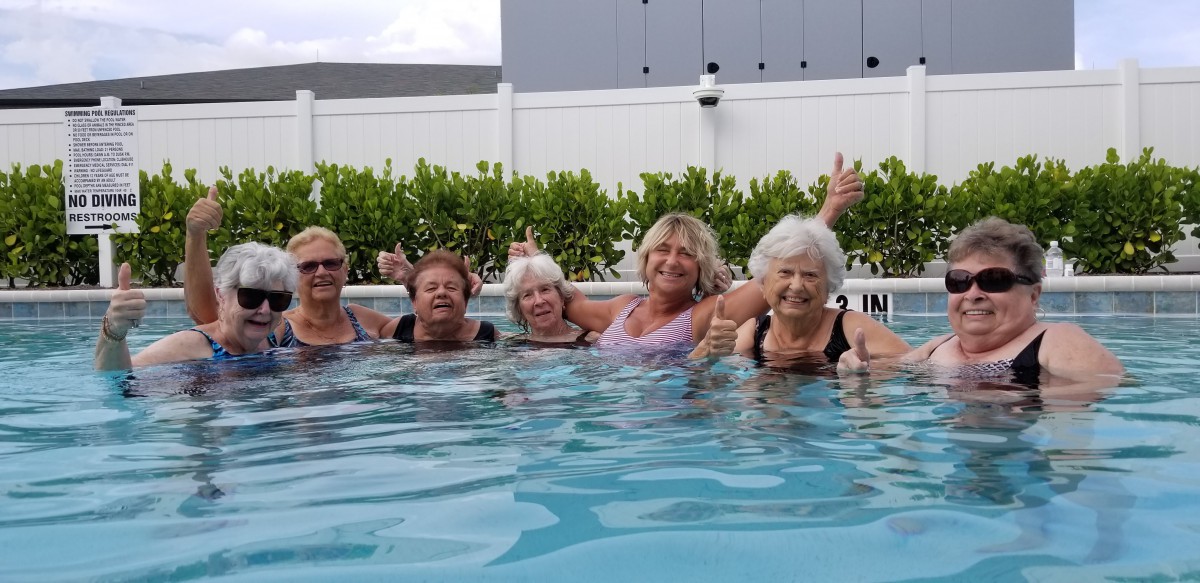 A group of women enjoying a fun time together in a swimming pool.