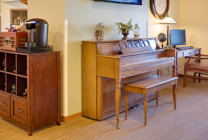 A cozy living room featuring a wooden piano and elegant decor.