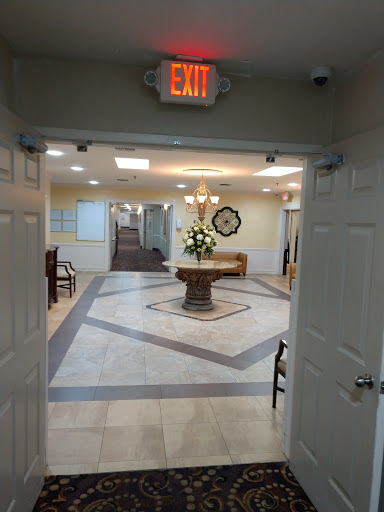 A view of a well-lit reception area featuring a decorative floral arrangement and elegant tile flooring.