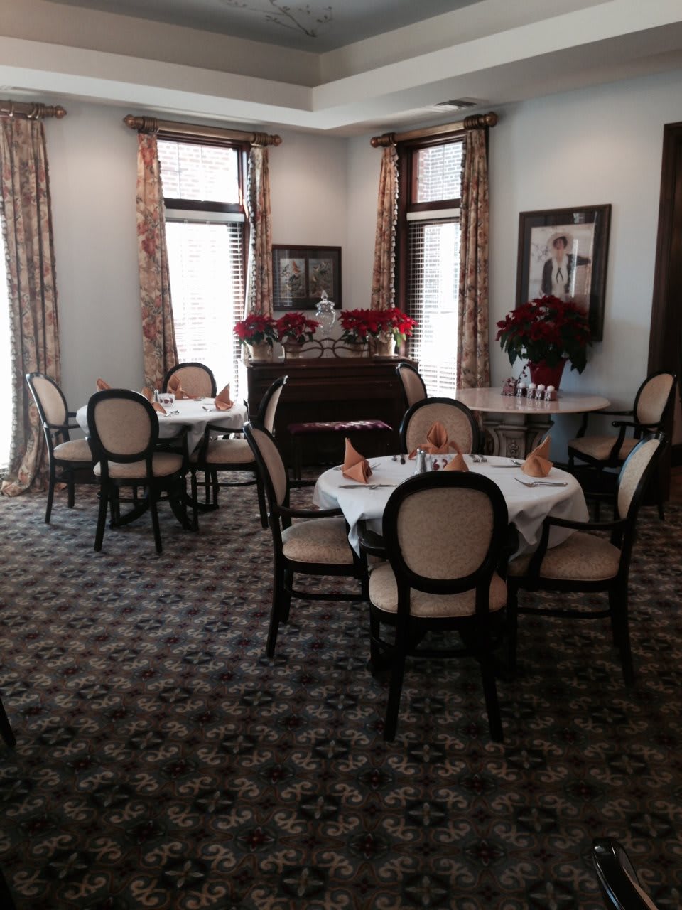A beautifully set dining area with elegant tables and chairs, located in a well-decorated restaurant interior.