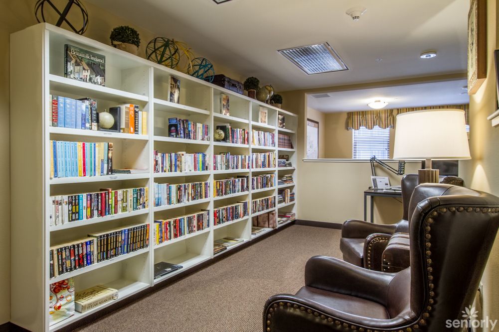 A cozy library corner with bookshelves and comfortable armchairs.