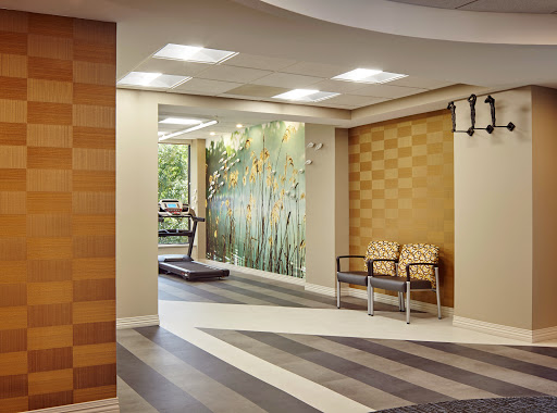 A modern waiting area with comfortable seating and a decorative wall featuring natural elements.
