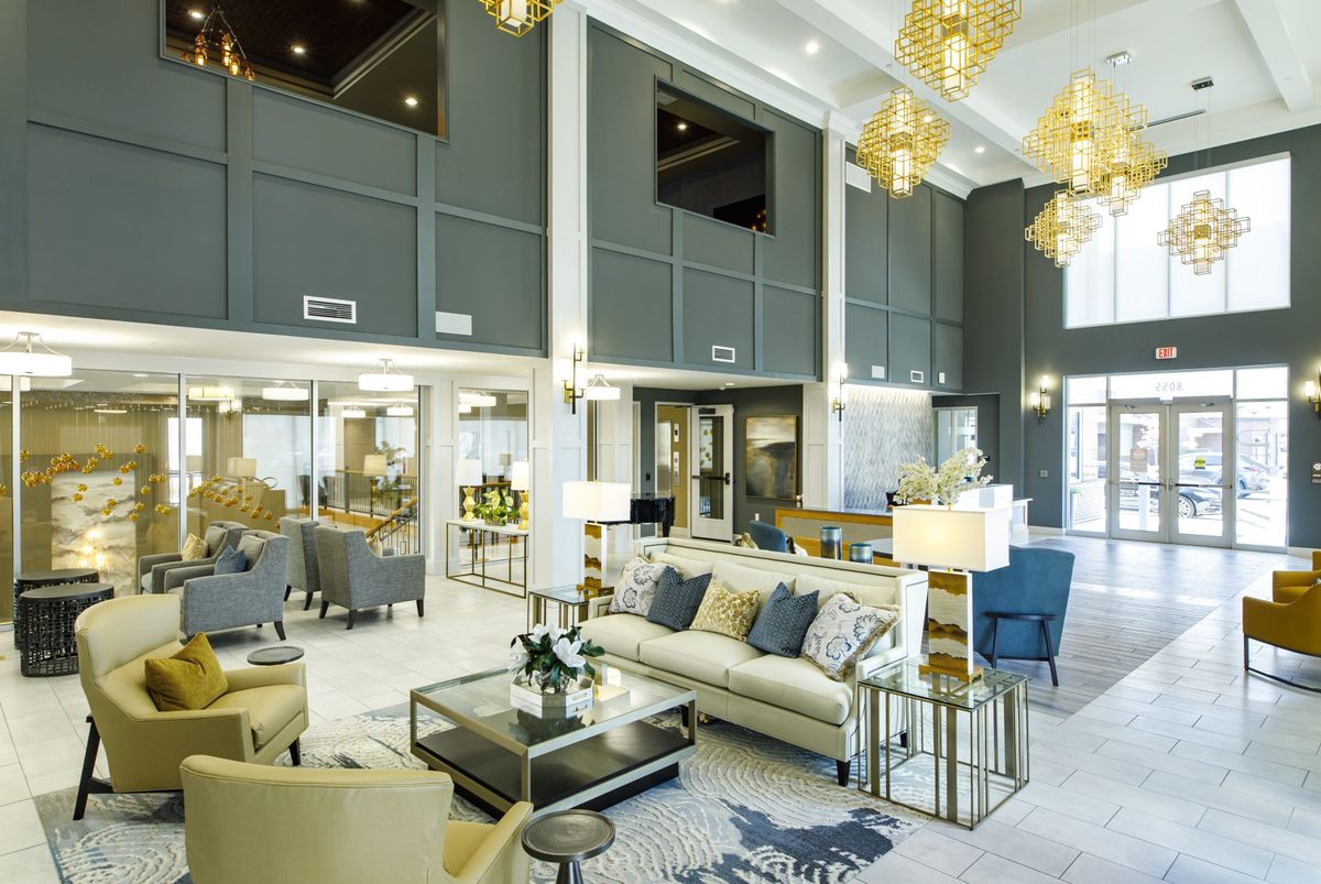 A luxurious and elegant living room with modern furnishings and chandeliers.