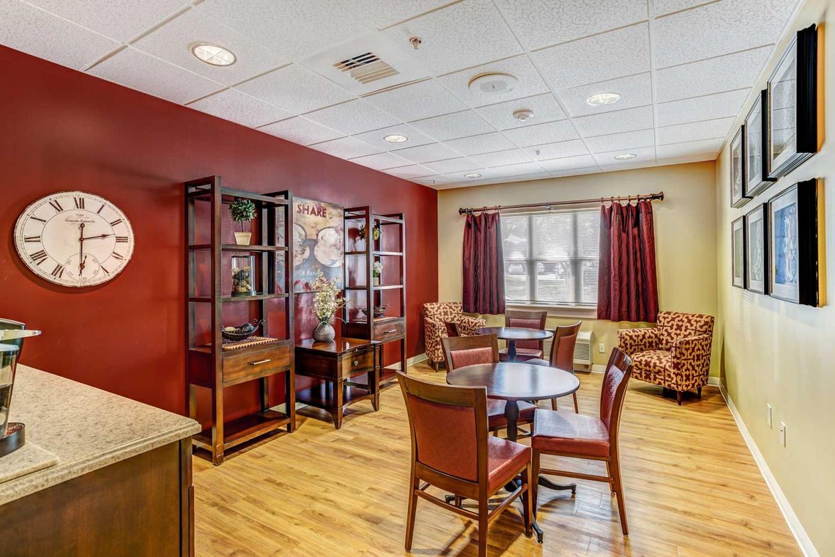 A cozy living area with wooden furniture, bookshelves, and warm decor.