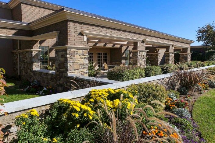 A beautifully landscaped building featuring brick and stone accents.
