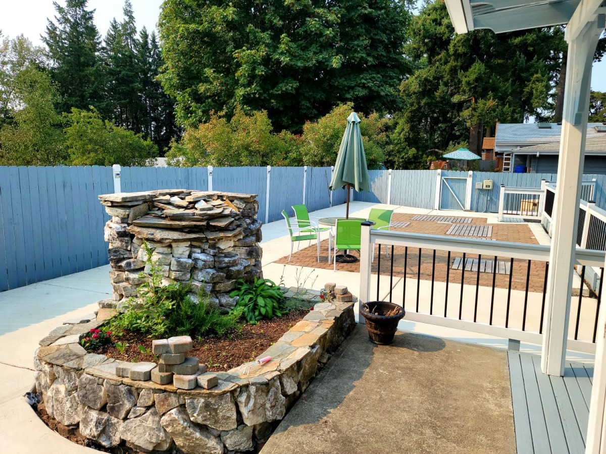 Outdoor garden patio with stone planters and seating area.