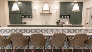 A modern kitchen with patterned tiles and stylish seating.