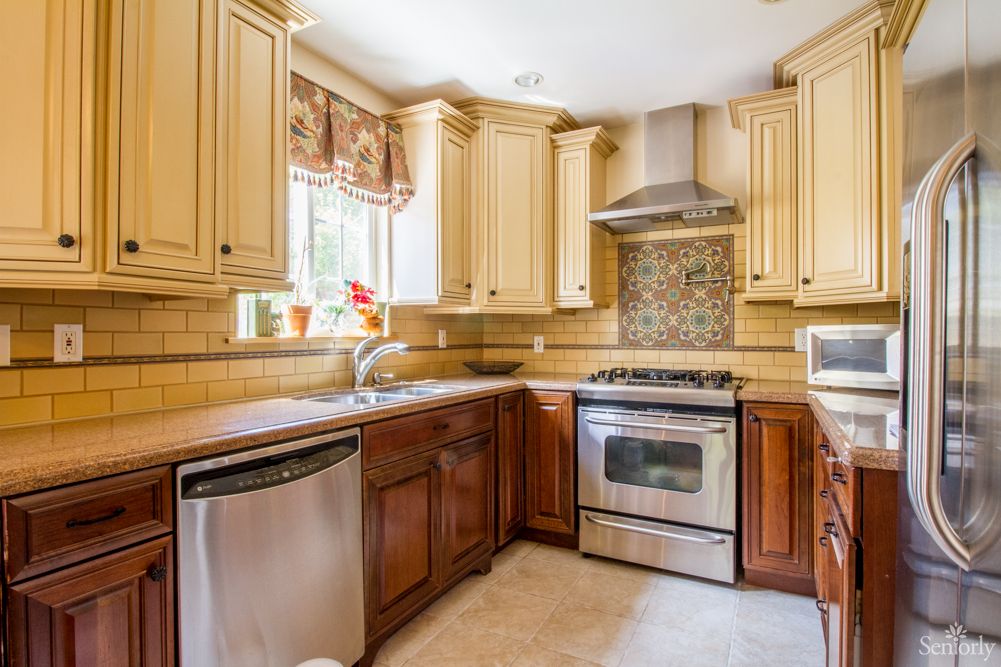 A modern kitchen with stainless steel appliances and wooden cabinets.