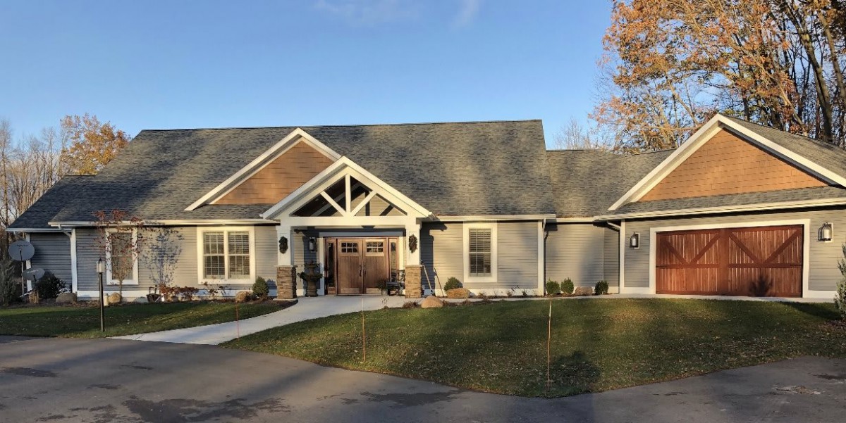 A beautiful single-story residential house with a spacious front yard and driveway, basking in the sunlight.