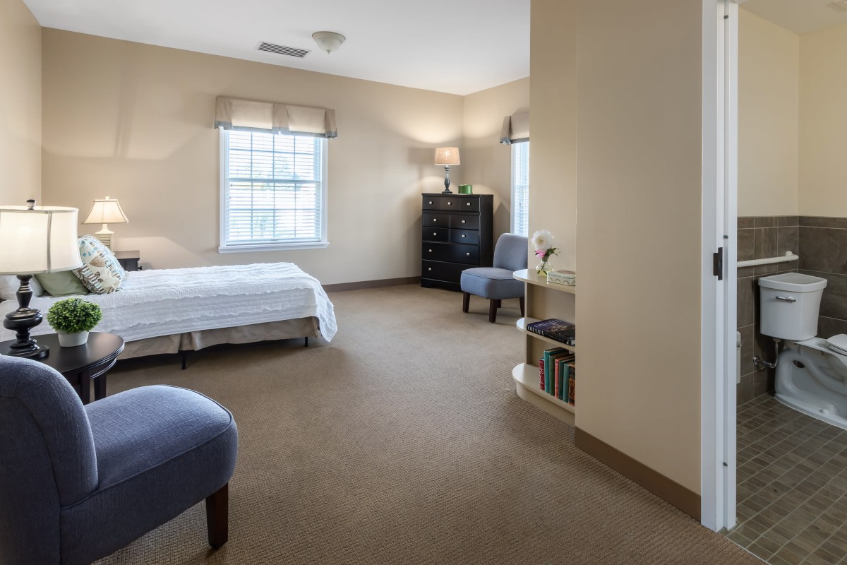 A minimalist bedroom with simple furniture and natural lighting.