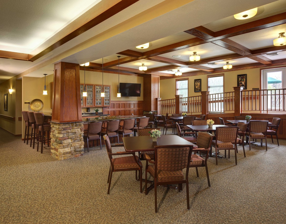 A modern restaurant interior with multiple tables and chairs set for dining.