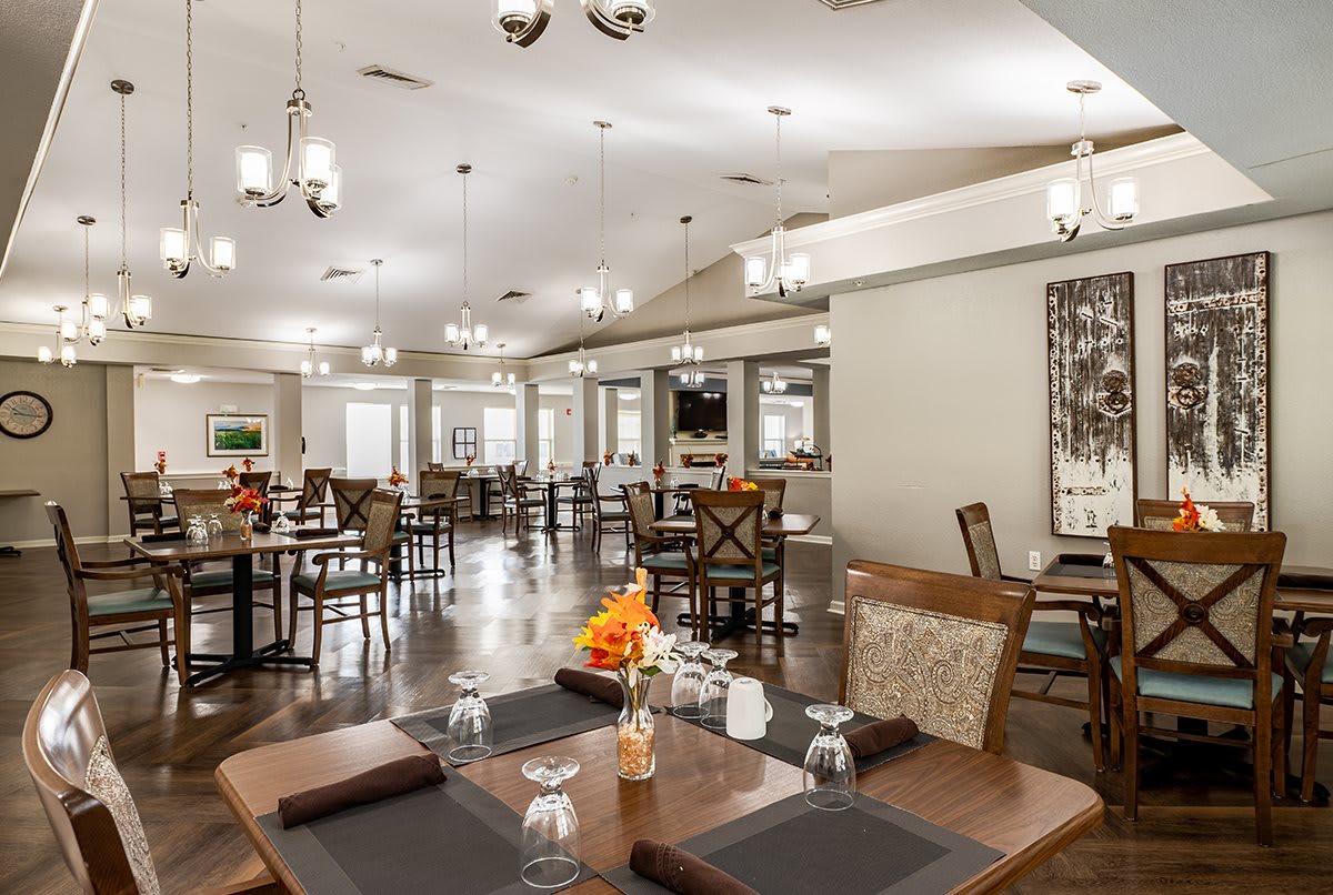 A spacious and elegantly designed dining area with neatly arranged tables and ambient lighting.