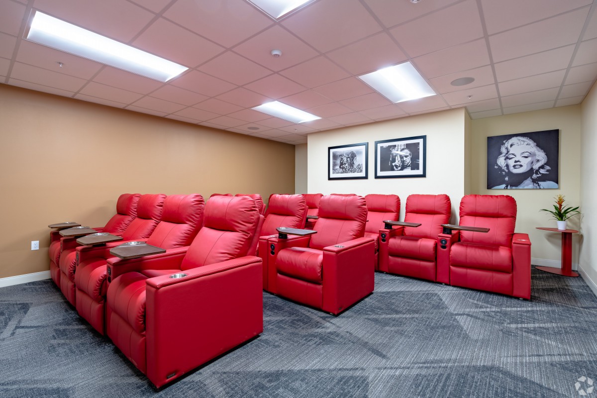 A cozy home theater setup featuring a row of plush red recliners.