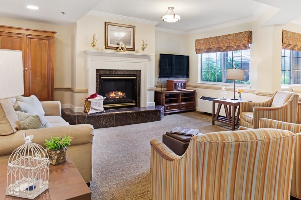 A cozy living room with a fireplace and comfortable seating arrangement.