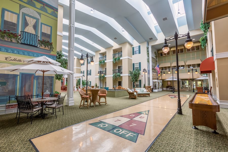 A spacious indoor atrium with natural lighting, featuring various seating areas and decorative elements.