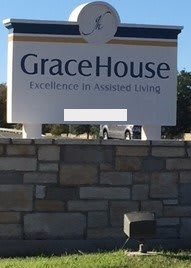 Sign for GraceHouse Assisted Living on a stone wall.