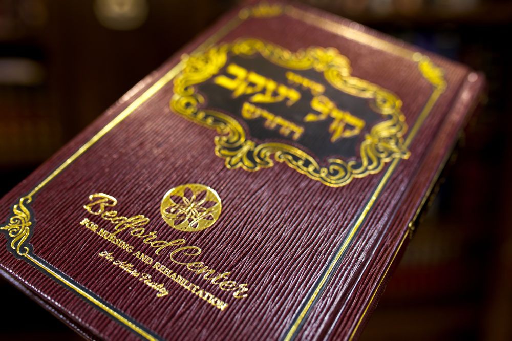 A close-up of a book with Hebrew text on its cover, often used in religious studies.