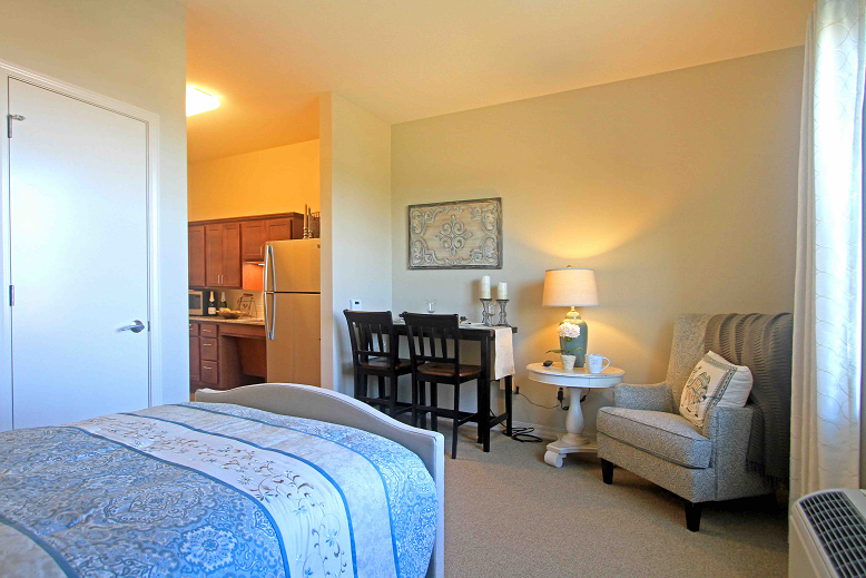 A cozy studio apartment with a visible kitchen, dining area, and living space.