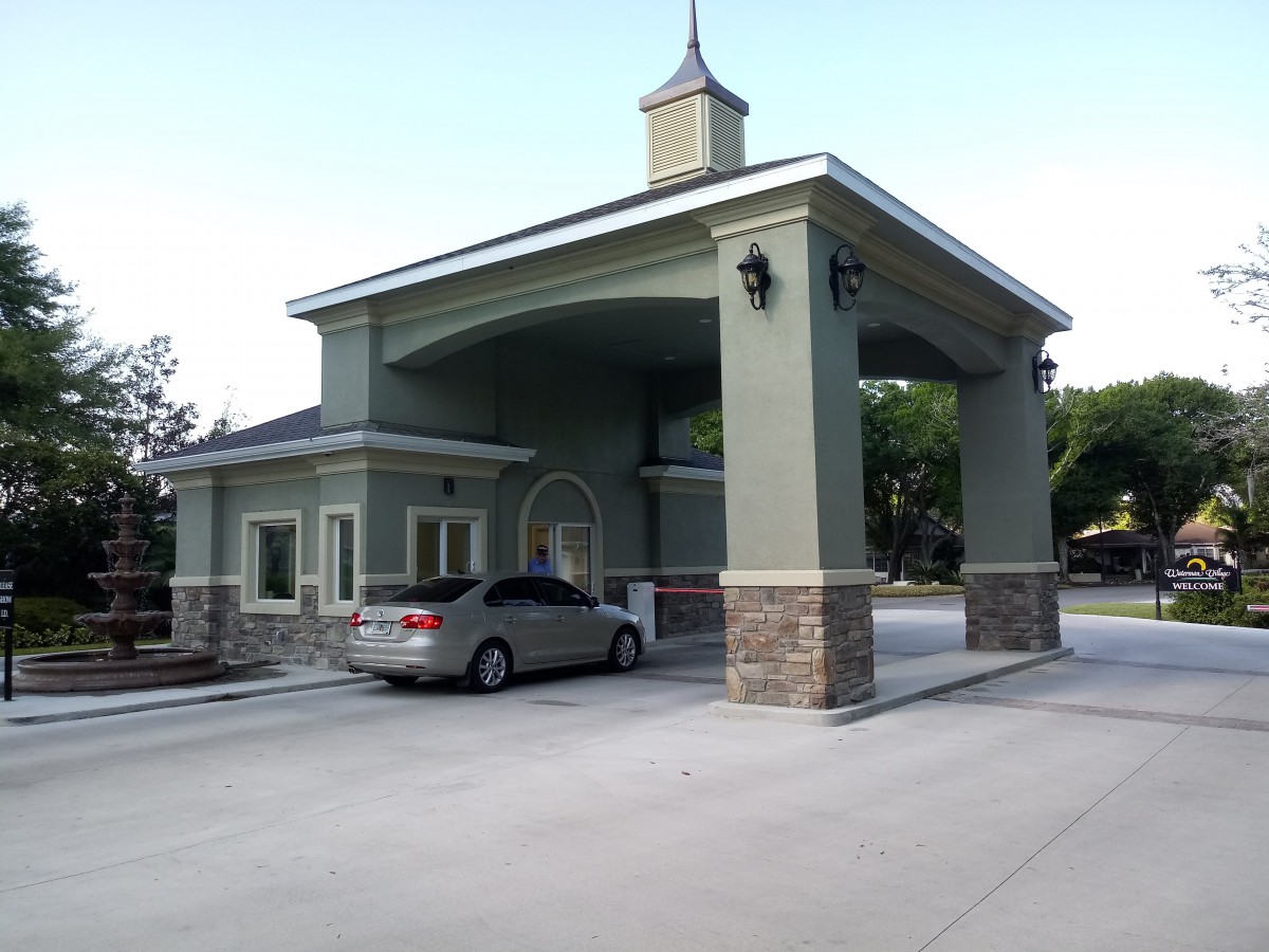 A car at a drive-thru building with a covered structure.