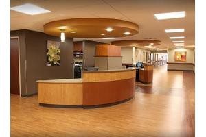 Modern reception area with a wooden desk and flooring.