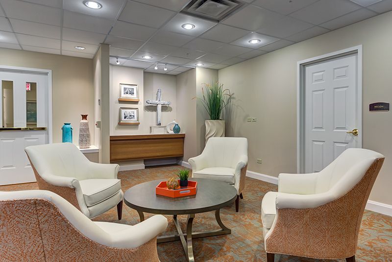 A cozy waiting room featuring elegant chairs around a central table with decorative elements.