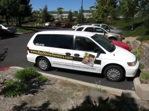 A white van parked in a lot featuring an advertisement on its side.