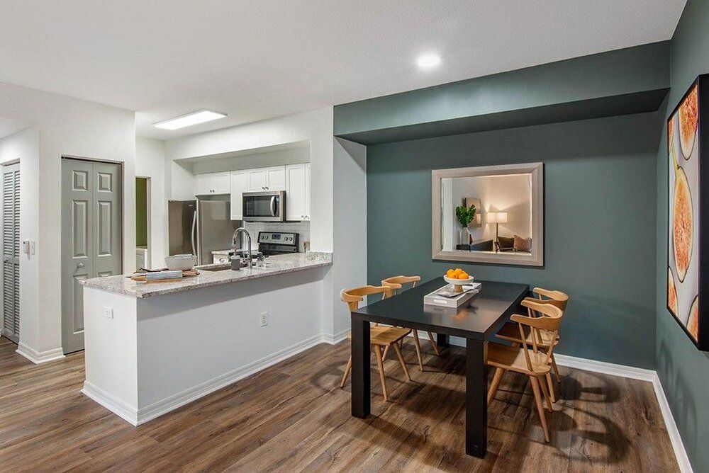 A modern apartment interior showcasing a stylish dining area and kitchen with sleek finishes.