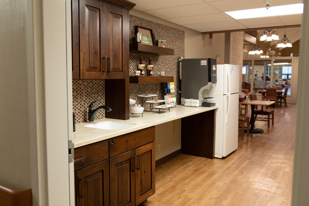 A cozy kitchen area with wooden cabinets, a countertop, a sink, and appliances.