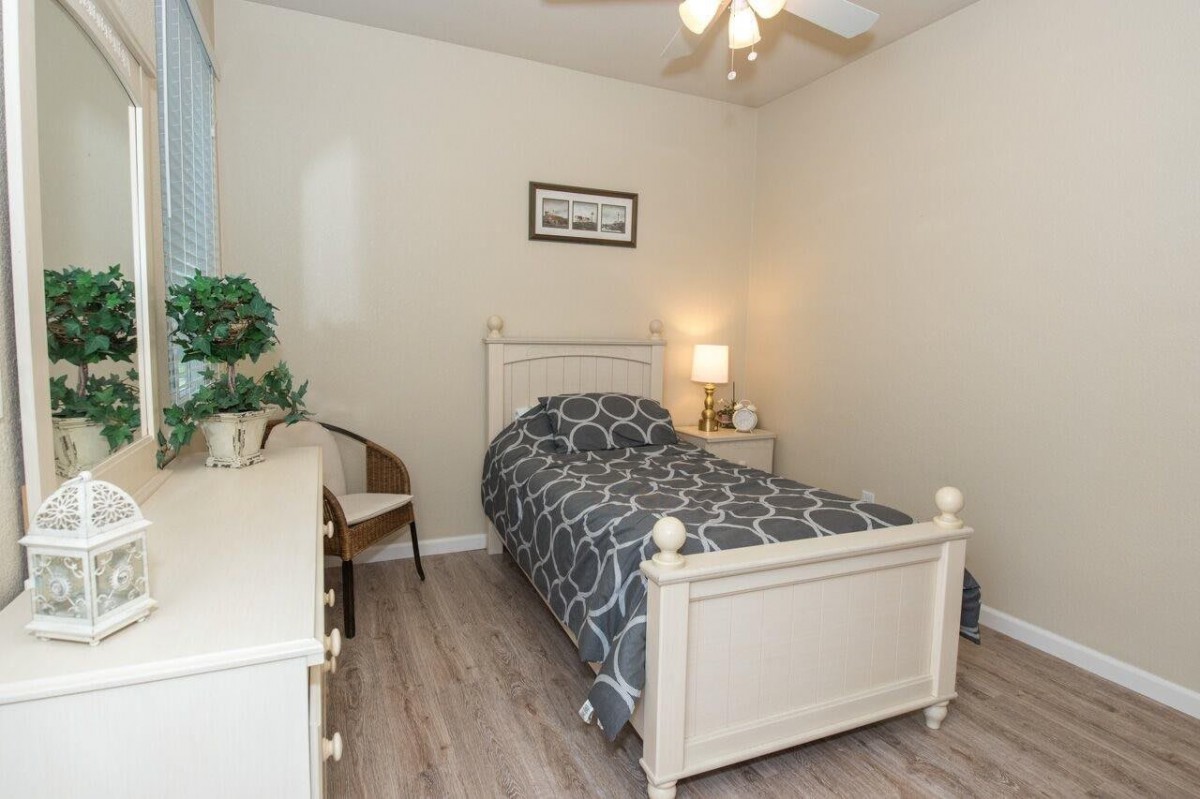 A cozy bedroom with a single bed, decorated with calming tones and minimal furnishings.