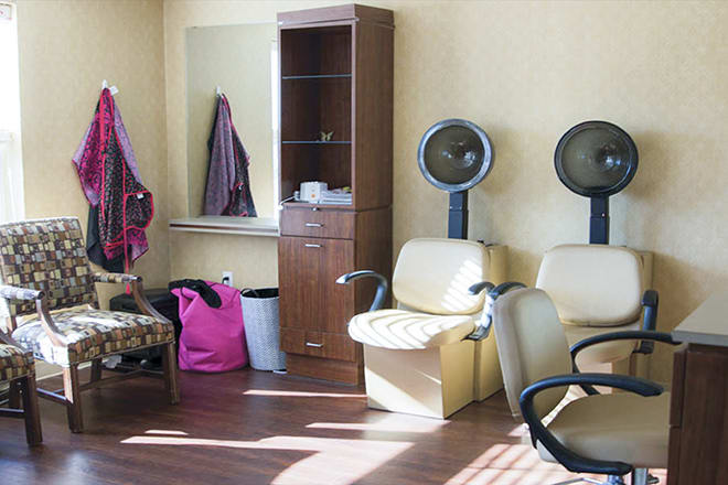 A cozy salon interior with chairs and hair dryers.
