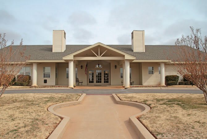 A front view of a symmetrical building with prominent columns and dual chimneys.