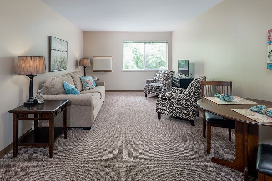 A cozy living room with neutral-colored furniture and a large window.