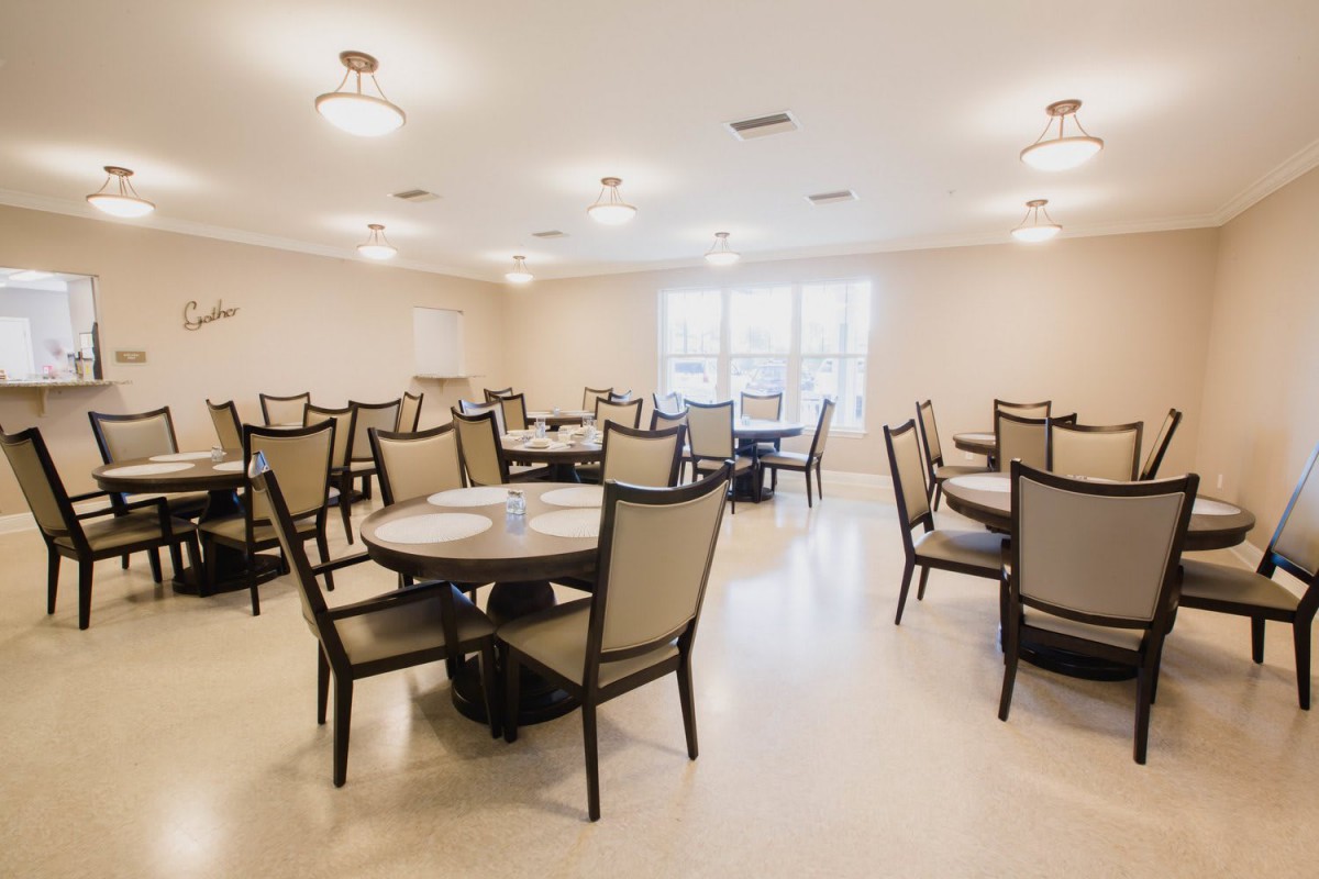 An empty dining room with neatly arranged tables and chairs.