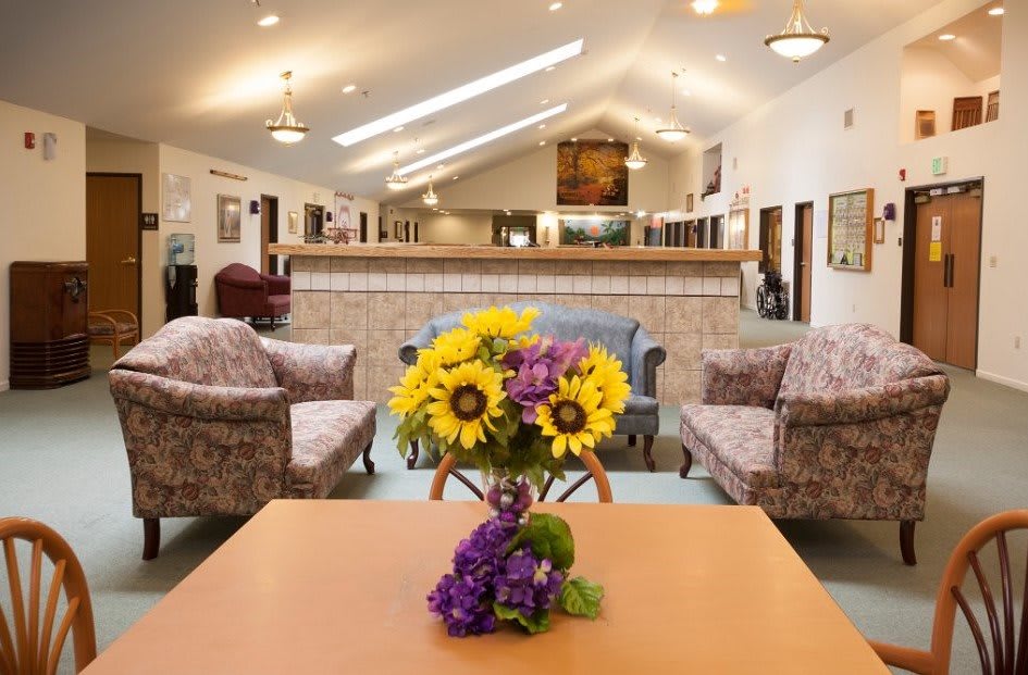 A cozy lobby with comfortable seating and a floral centerpiece on the table.