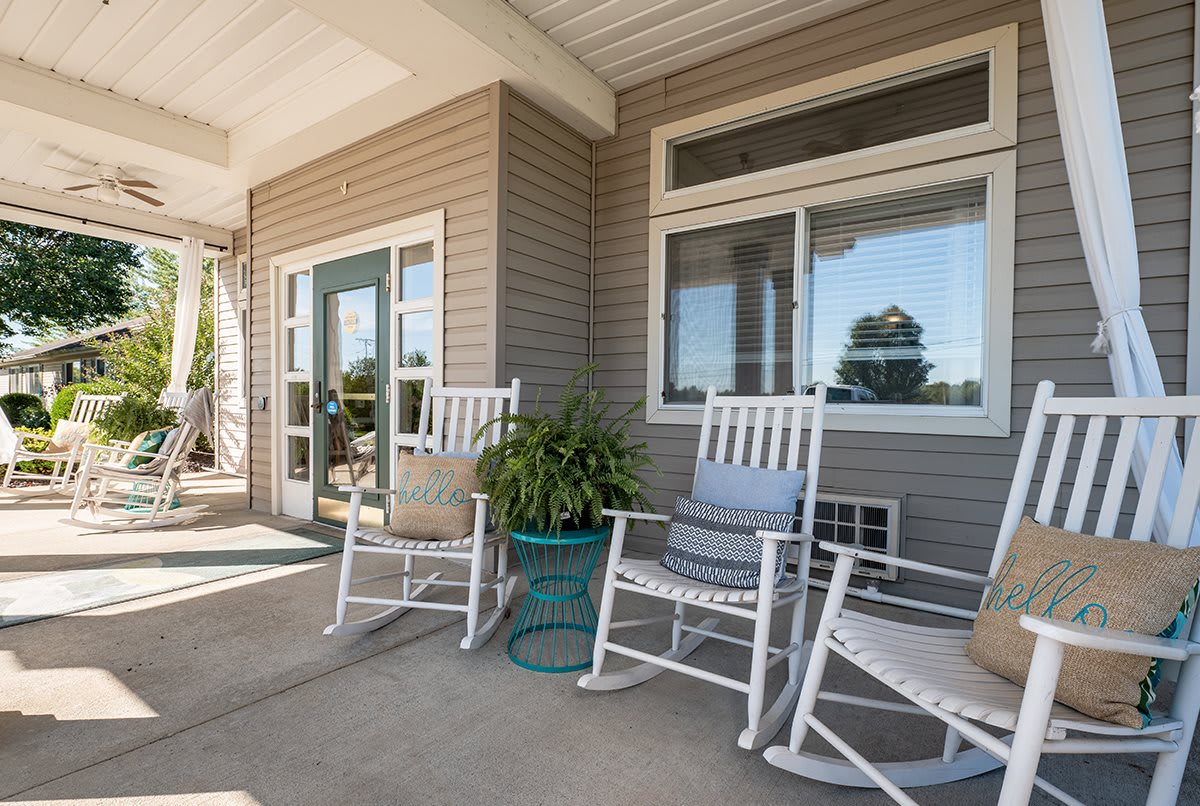 A cozy porch with rocking chairs and a potted plant.