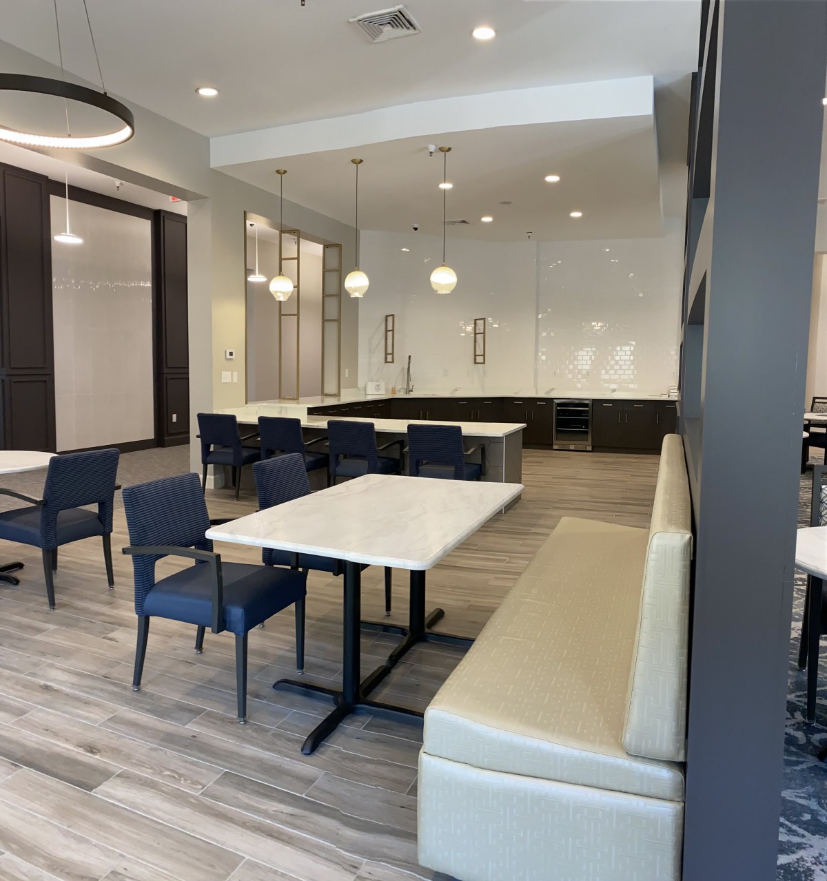 A modern dining area with neatly arranged tables and chairs, featuring stylish lighting.