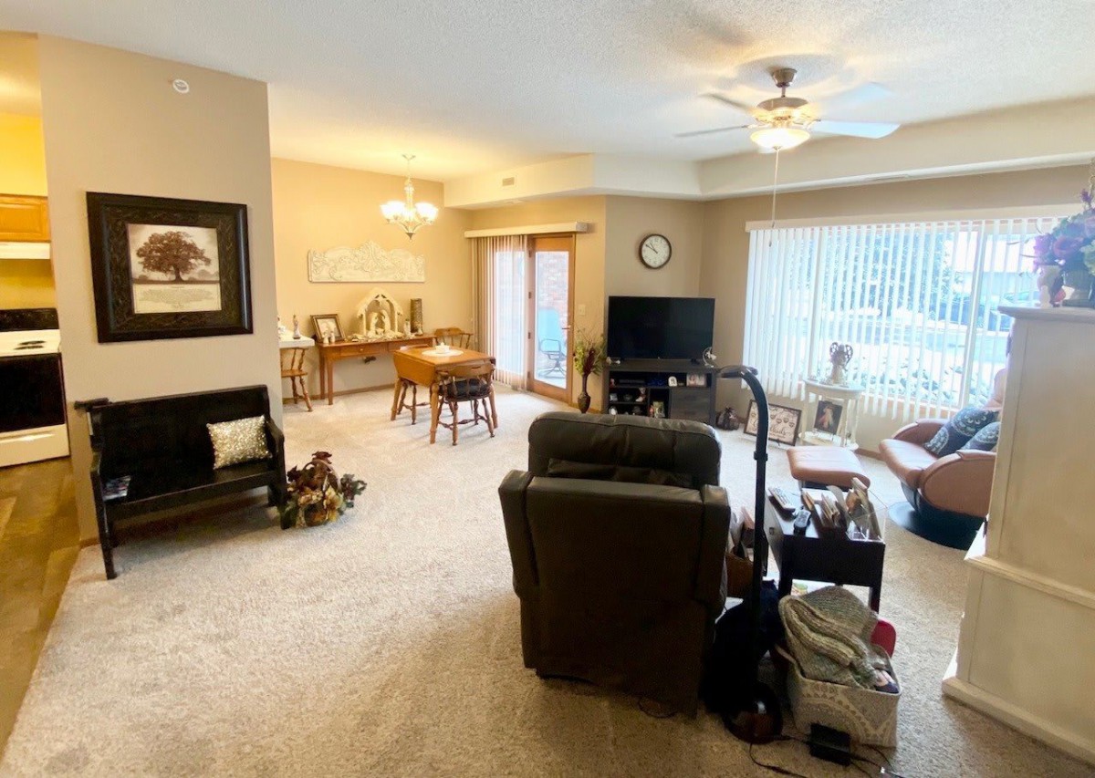 A cozy living room with a dining area, featuring comfortable seating and a television.