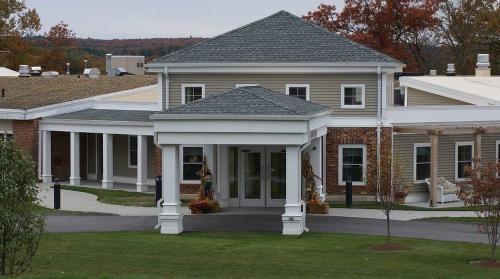 Front view of a residential building with a covered entrance and columns.