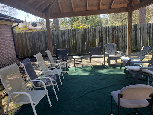 A cozy outdoor seating area with various chairs arranged for a gathering.