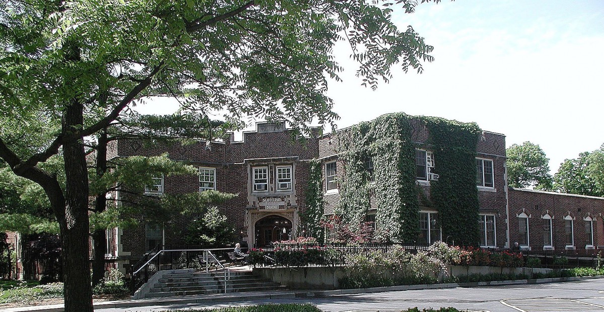 A historical brick building covered in lush green ivy.