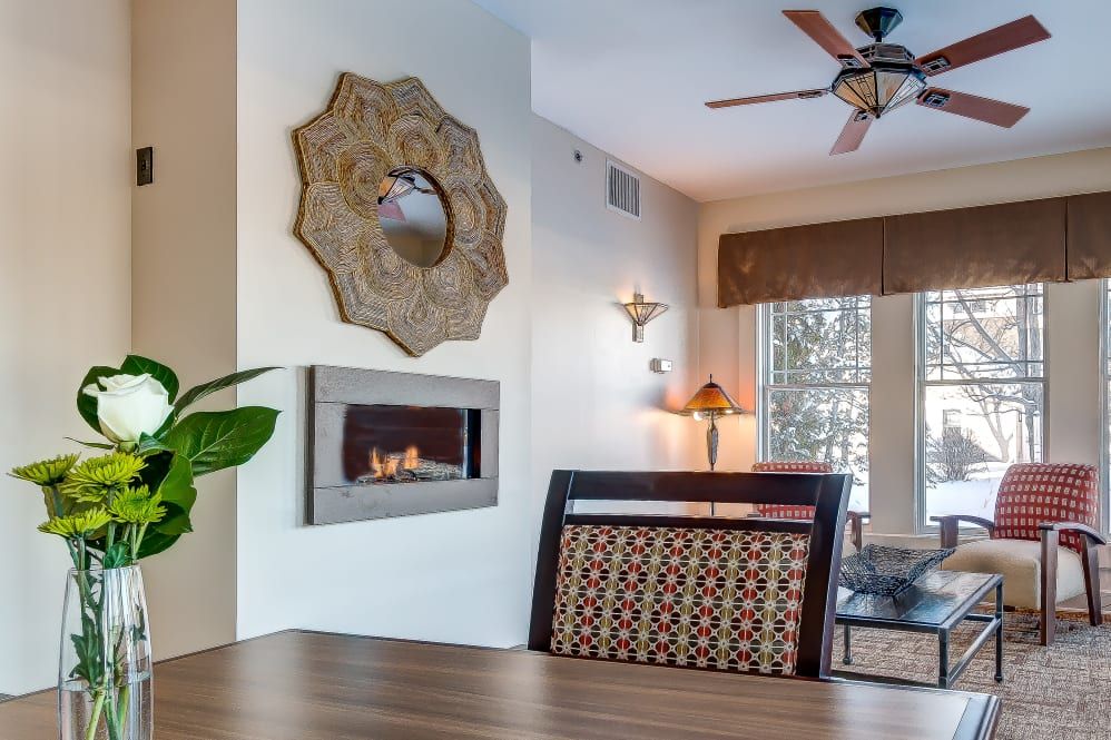 A modern living room with a stylish fireplace, wall art, and furnishings.